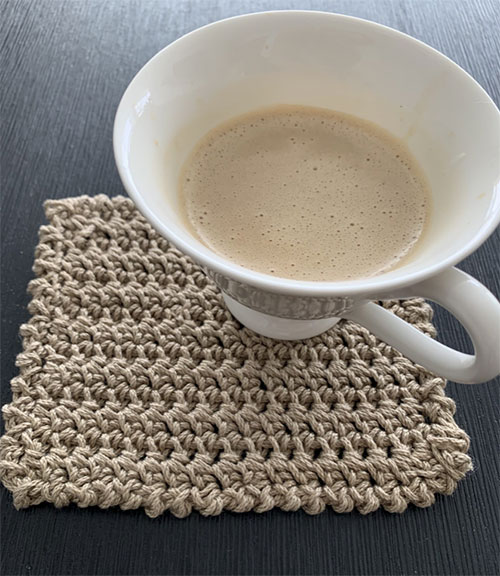 Cafe latte rug mug photo of a cup off coffee on the beige-brown mug rug.