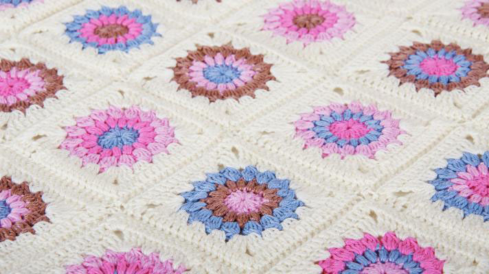 granny square phot of a granny square blanket in pinks and white 