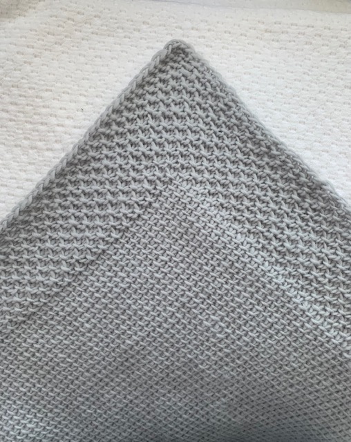 tunisian crochet project photo of a gray shawl, close up of the corner 