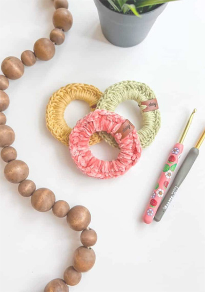 crochet stocking stuffers photo of pastel scrunchies with crochet hooks photo credit to Daisy Farm Crafts