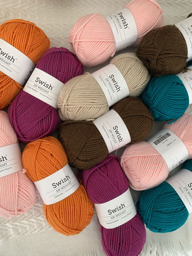 photo of swish yarn balls in purples, orange, teal, pink and browns against a white background 