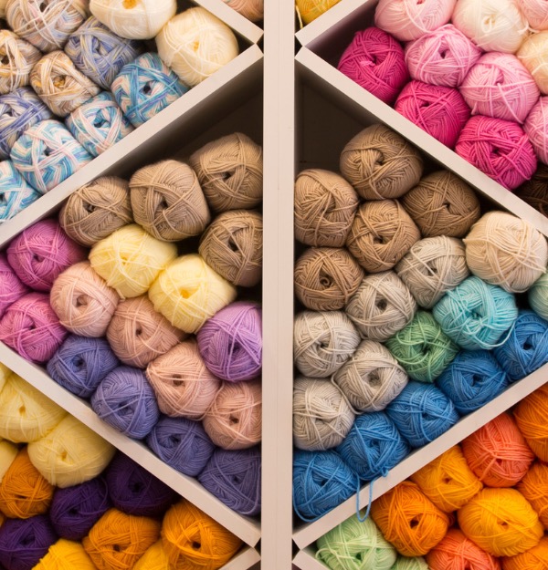 Photo of a yarn shelf with various colours of yarns on it photo of how to use your yarn stash 