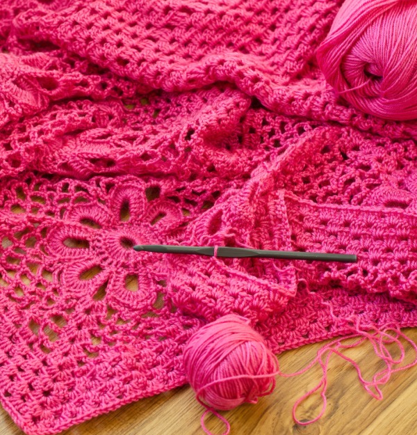 Photo of bright pink crochet against a wood background photo of how to use your yarn stash 
