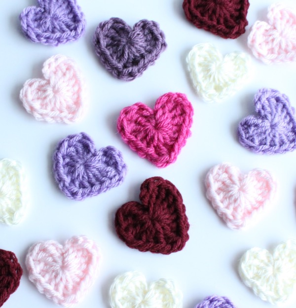 Photo of heart shaped appliqués in purple, pinks and dark red against a white background photo for how to use your yarn stash 