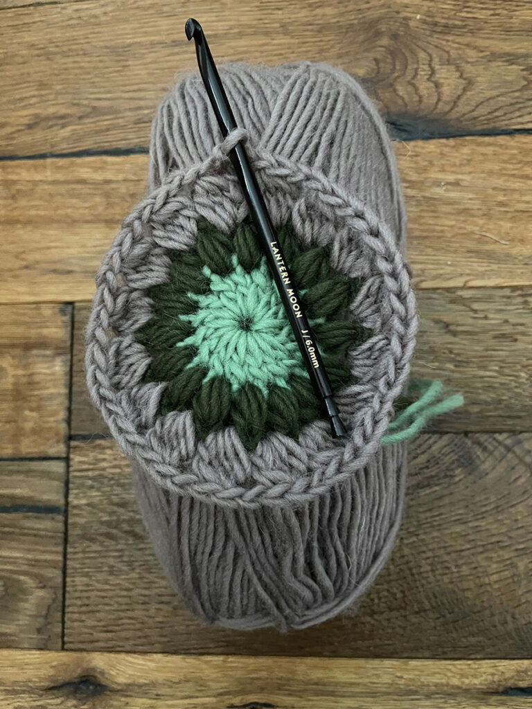 A lantern moon hook crocheting a granny circle on top of a ball of yarn Lantern Moon hook review photo 