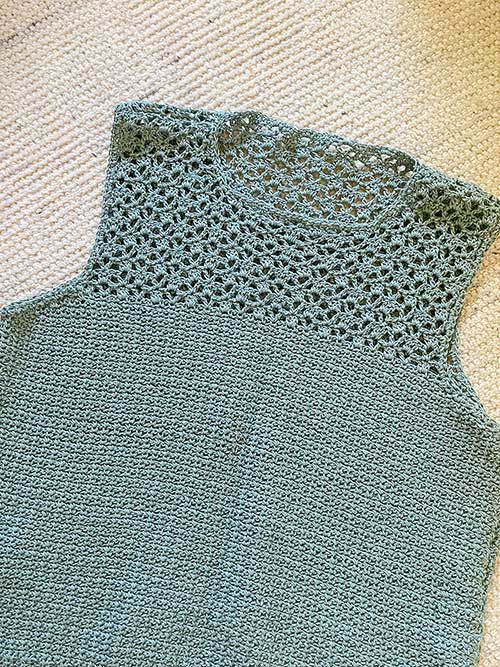 photo of sage green crochet tee with openwork lace against a white background