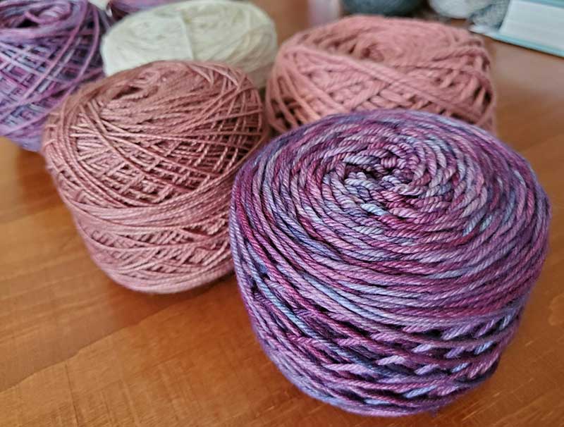 picture of cakes of yarn in pinks and purples 